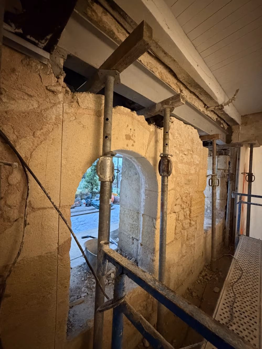 Étais en place autour d'une ouverture en arc dans un mur en pierre