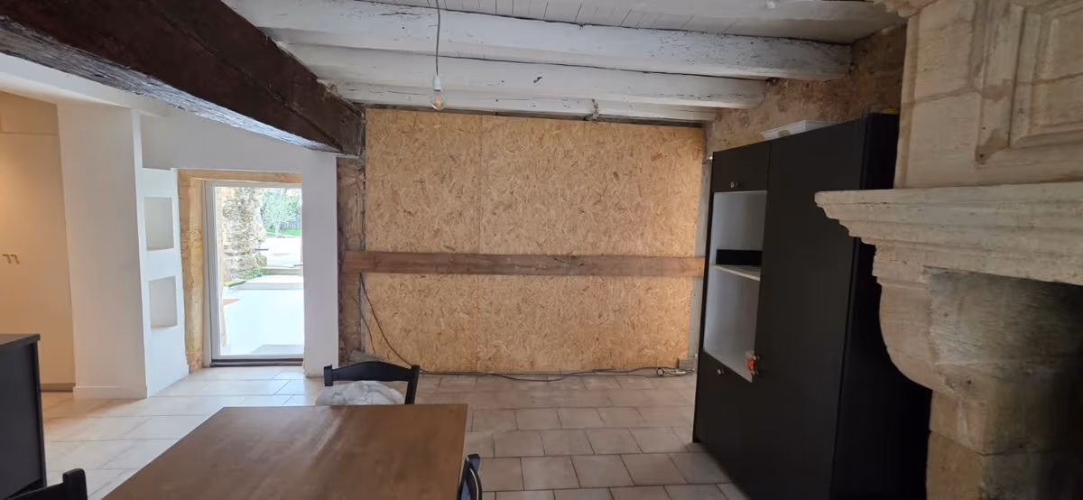 Pièce en cours d'aménagement avec cheminée en pierre